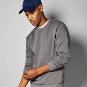 Man wearing a K332 Kustom Kit Regular Fit Sweatshirt paired with a professional cap, suitable for a versatile work wardrobe.