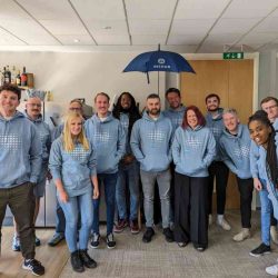 Group of professionals in custom embroidered workwear featuring company branding, gathered for a corporate event.