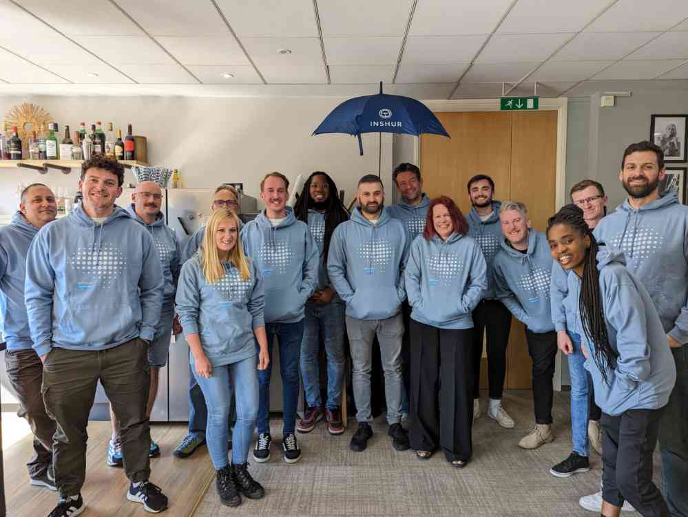 Group of professionals in custom embroidered workwear featuring company branding, gathered for a corporate event.