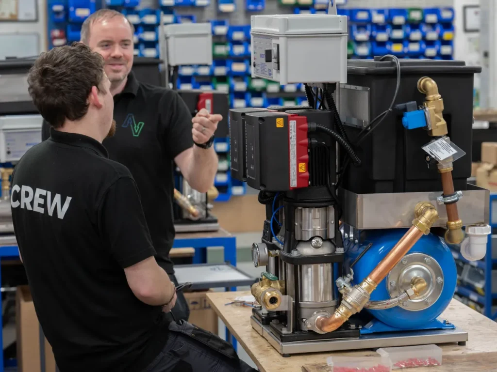 Engineers in branded polo shirts at work in their workshop