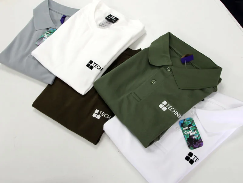 Branded polo shirts laid out after embroidery
